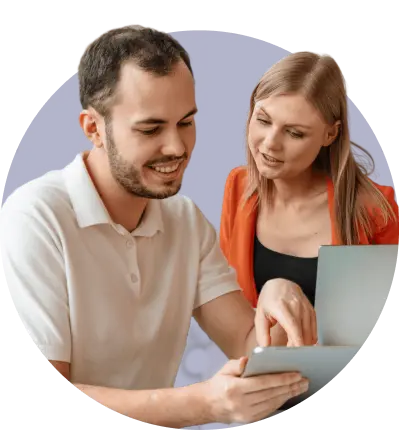 Two managers happily looking at a laptop managing shift rotas and employee schedules
