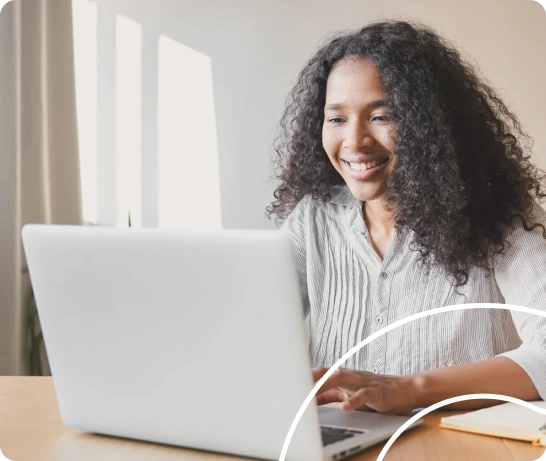 A happy new employee reviewing company handbook and onboarding materials on laptop