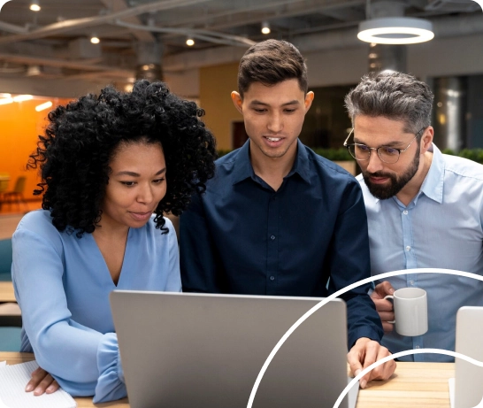 A diverse team collaborating over a laptop to group employees for faster schedule and shift assignments in Crewlix